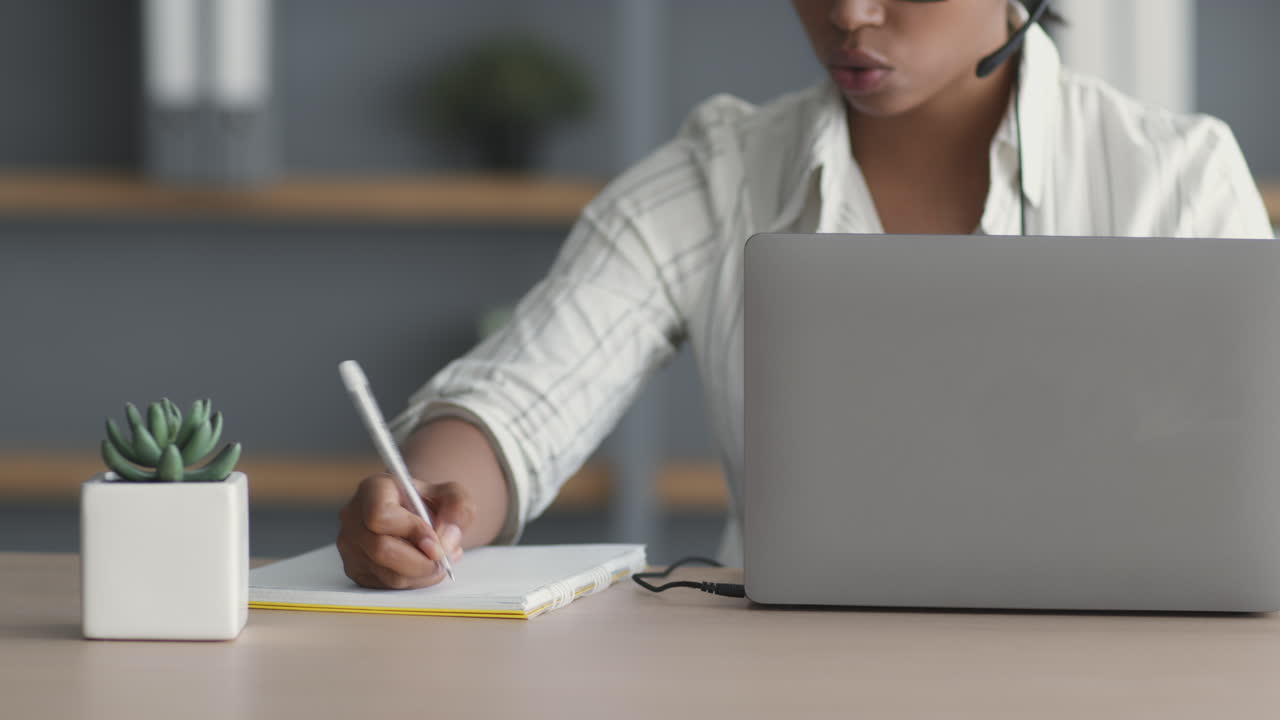 mujer tomando notas durante una llamada de video
