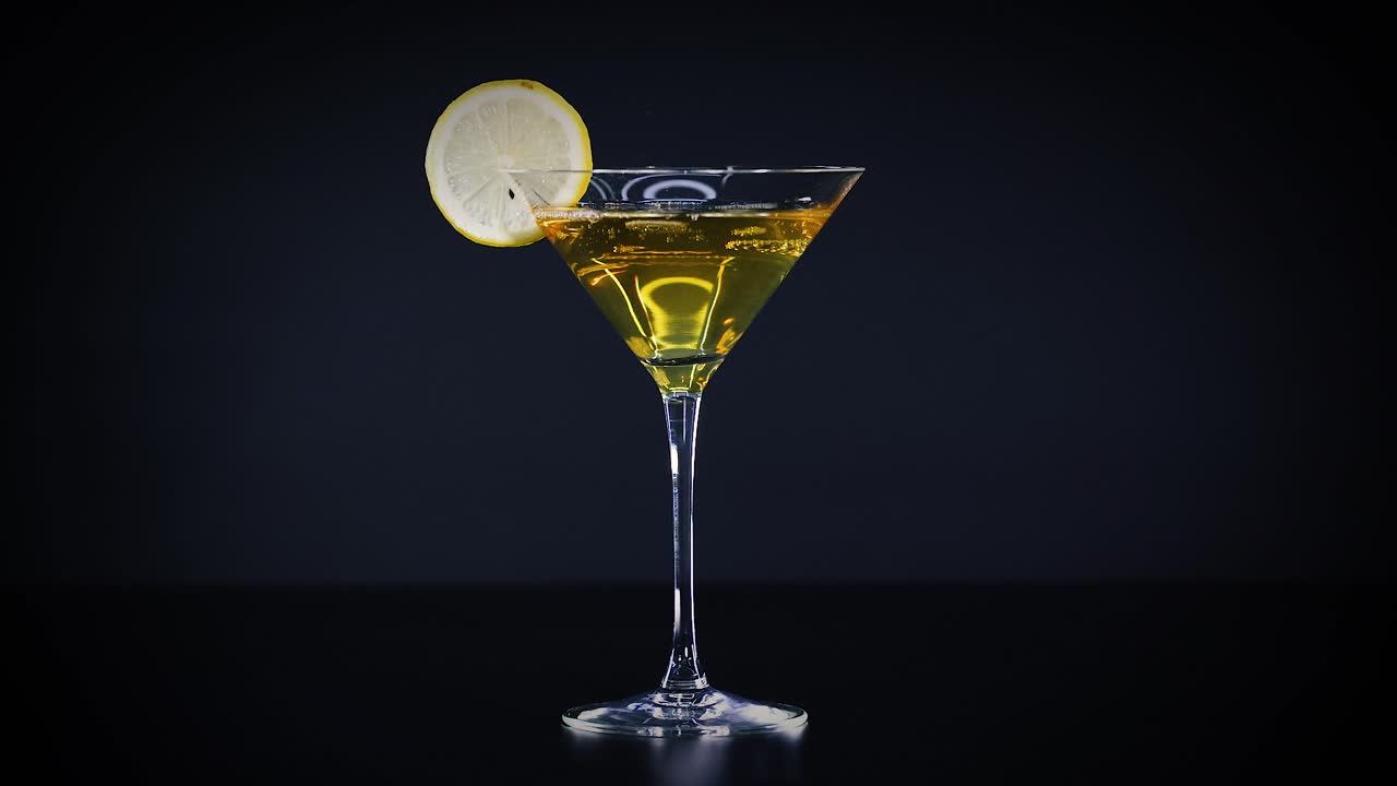 Bicchiere da Martini con fetta di lime su sfondo nero
