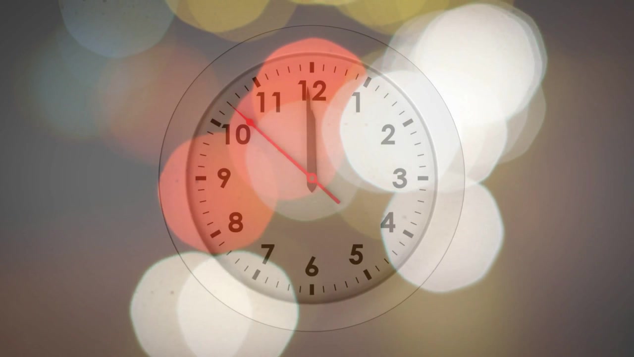 再生中のアナログ時計の針が時計回りに動き、色とりどりのボケが右に流れながら秒を表示している様子。