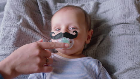 portrait cute baby with moustache pacifier sucking on dummy