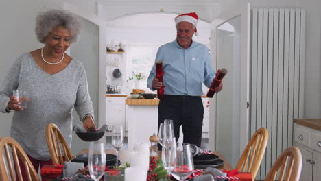 Pareja-Mayor-En-Casa-Preparando-Y-Decorando-La-Mesa-Para-Comer-El-Día-De-Navidad