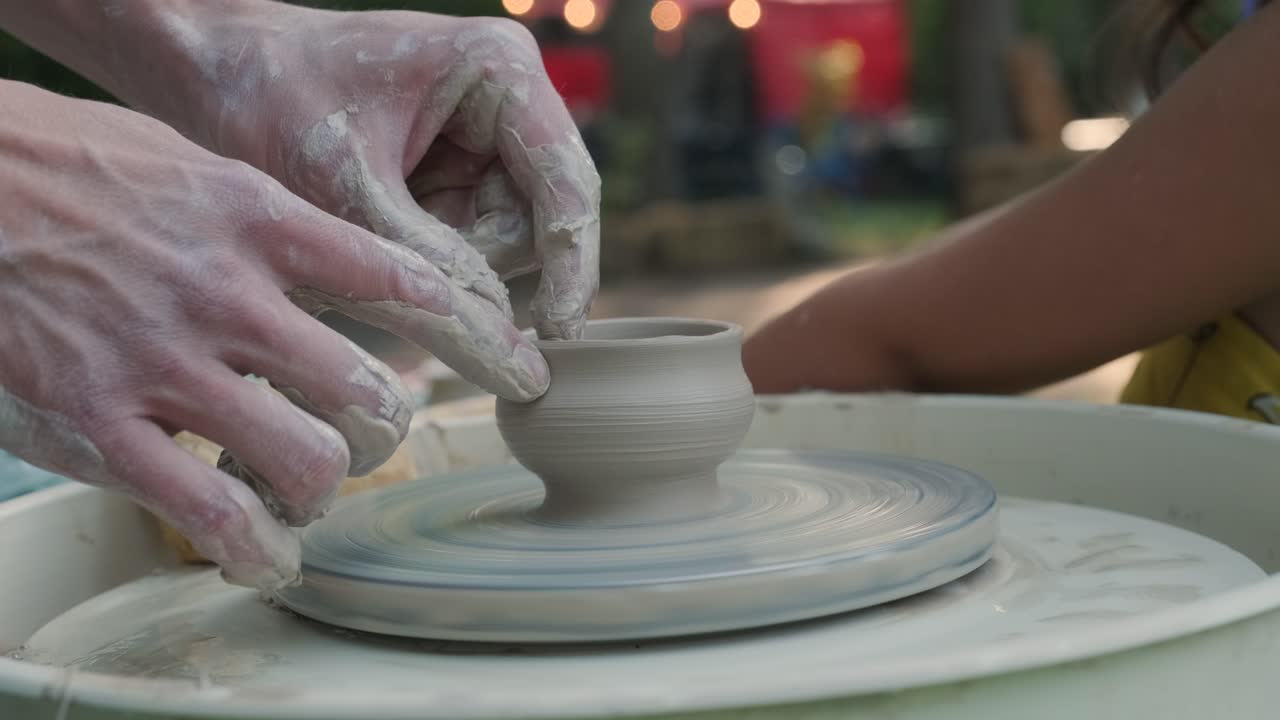 도자기의 바에서 점토로 작업하는 손의 가까운 모습. 공예가 도자기 바에 점토 제품을 형성합니다.