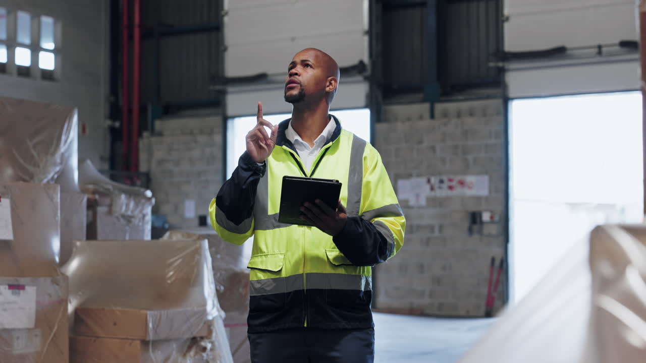 un hombre en un almacén trabajando en una tableta