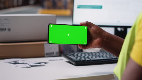 vertical video staff reviews green screen pc in the storage room for data entry