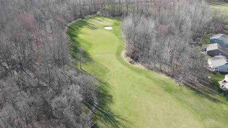 Flying-over-a-hole-on-a-golf-course-on-a-bright-sunny-day-in-early-sping