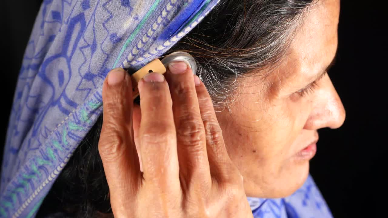 mujer ajustando el audífono