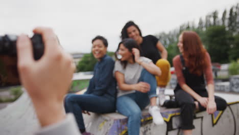 group of female friends posing for photo on camera in urban skate park