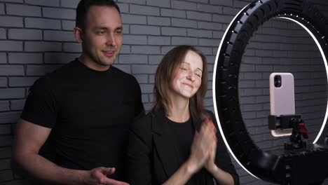 shooting of couple with smartphone on brick wall background