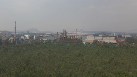 vasto complejo de centrales eléctricas, vista desde arriba, rodeado de vegetación verde, humor de niebla
