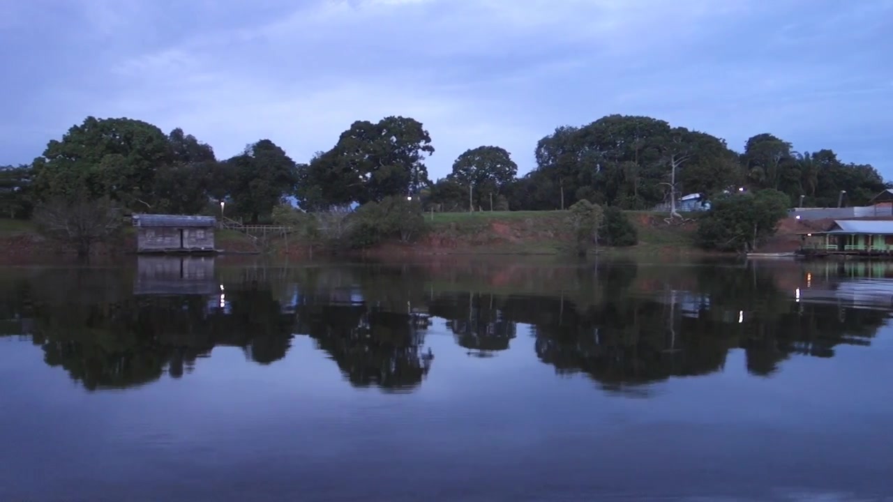 Case galleggianti in legno lungo le rive di un fiume tropicale vicino a Manaus, Brasile, al crepuscolo