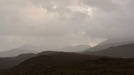 a moody scottish landscape with layers of mountains