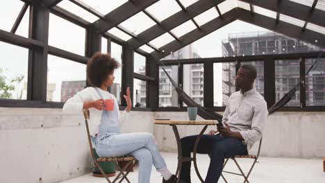 african man and mixed race woman discussing on rooftop