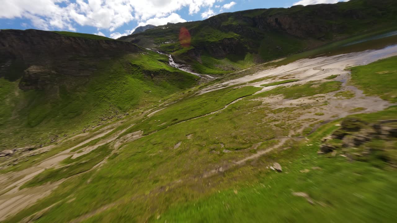 vuelo a baja altitud sobre un valle verde en un día de verano en la carretera alpina grossglockner en austria