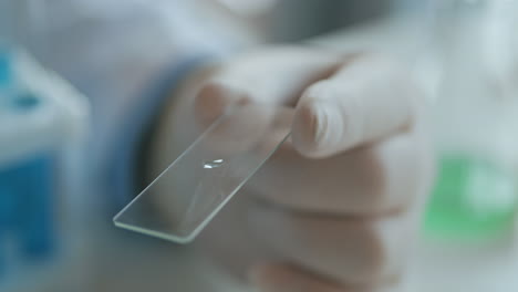 Mujer-Técnica-De-Laboratorio-Aplicando-Gotas-De-Sangre-En-Un-Portaobjetos-De-Vidrio-De-Una-Pipeta-En-El-Laboratorio-En-Cámara-Lenta-Con-Las-Manos-En-Látex.-Imágenes-4k-De-Alta-Calidad