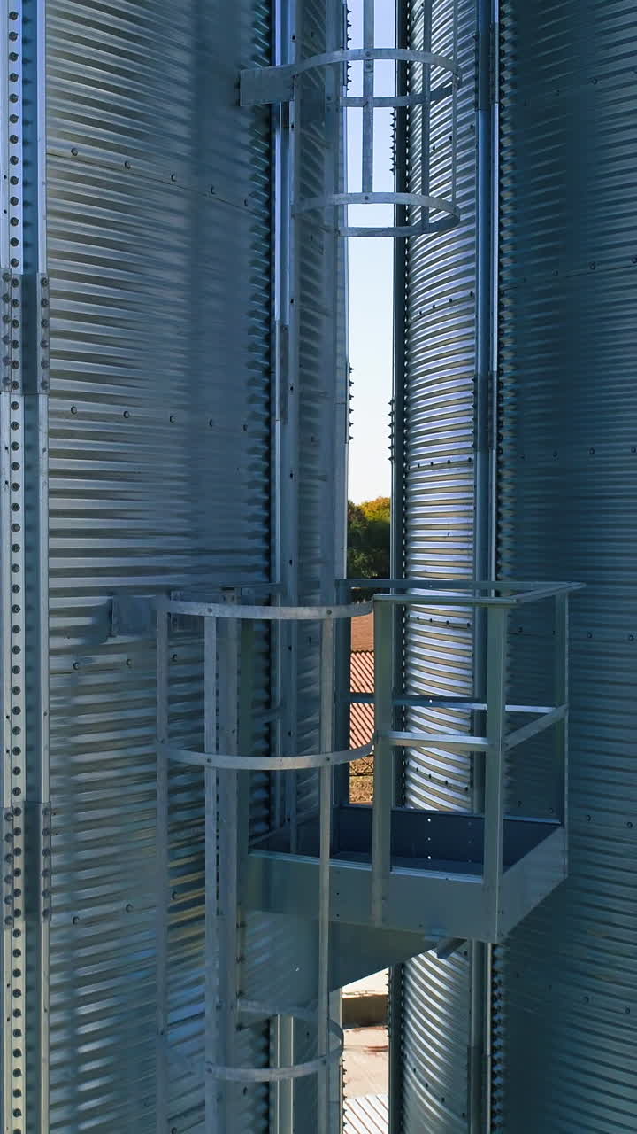 Metal elevator in agriculture zone. Grain Warehouse or depository. Vertical video