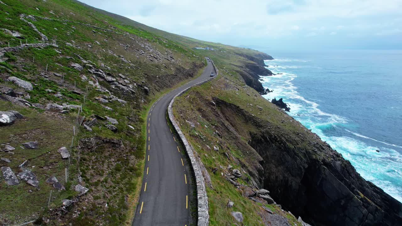 Drone view of Slea Head drive winding above high cliffs and the Atlantic Ocean early morning in Kerry Ireland EpicLocation