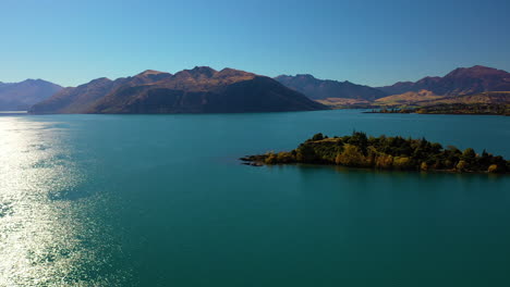 Aerial-flying-over-a-glacial-lake-toward-mountains-in-New-Zealand