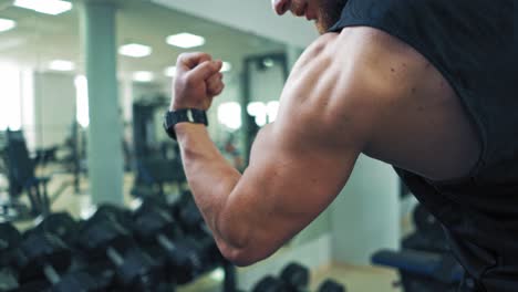 fitness woman training in gym. strong muscular bodybuilder athlete man posing and pumping up muscles at gym