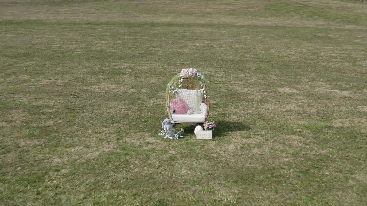 Drone zoomer ind på påskepynt på en græsmark