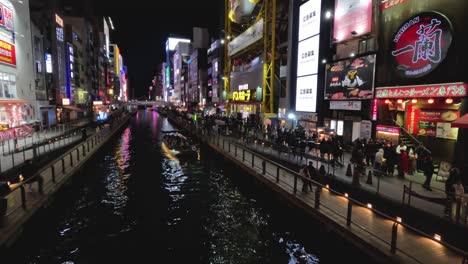 evening view of a vibrant city canal with neon signs