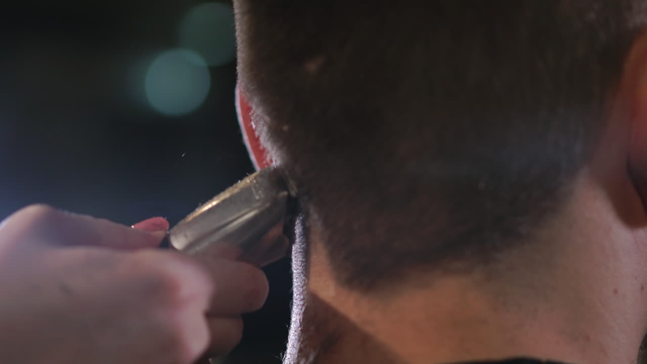 Hairdresser tools. Close up of male hands brushing electric hair clippers. Hairdressers prepare hair machine for next client. Man clean black shaving machine