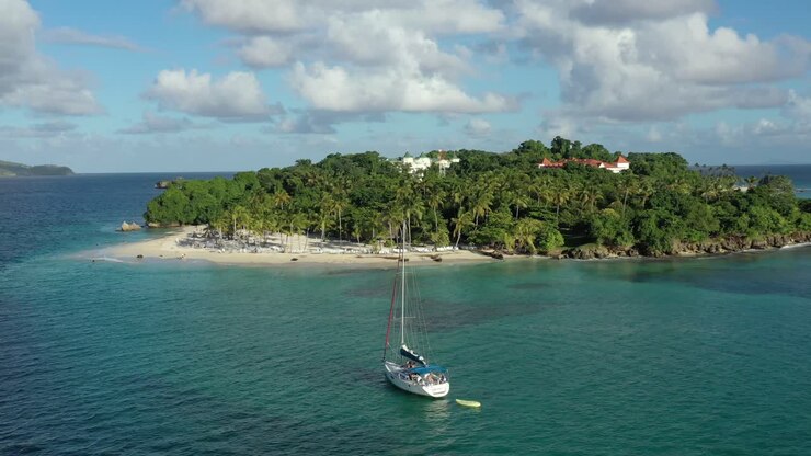 Persone a bordo di una barca a vela ancorata sull'acqua di mare trasparente di Cayo Levantado, Samaná.