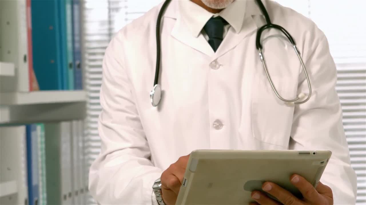 Confident doctor using tablet
