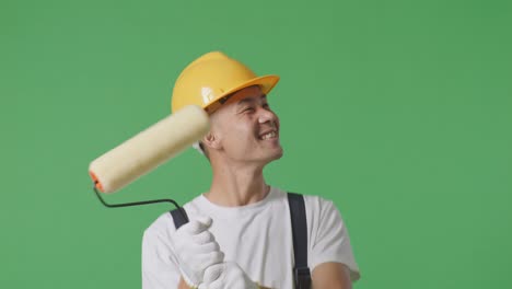 Close Up Of Asian Man Painter Wearing Safety Helmet Dancing While Standing In The Green Screen Background Studio