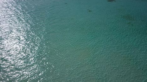 the clean, pristine, clear waters of the maldives reflecting the light of the bright sun - aerial shot