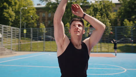 athletic man in sportswear playing basketball game successfully throws ball into the basket ring