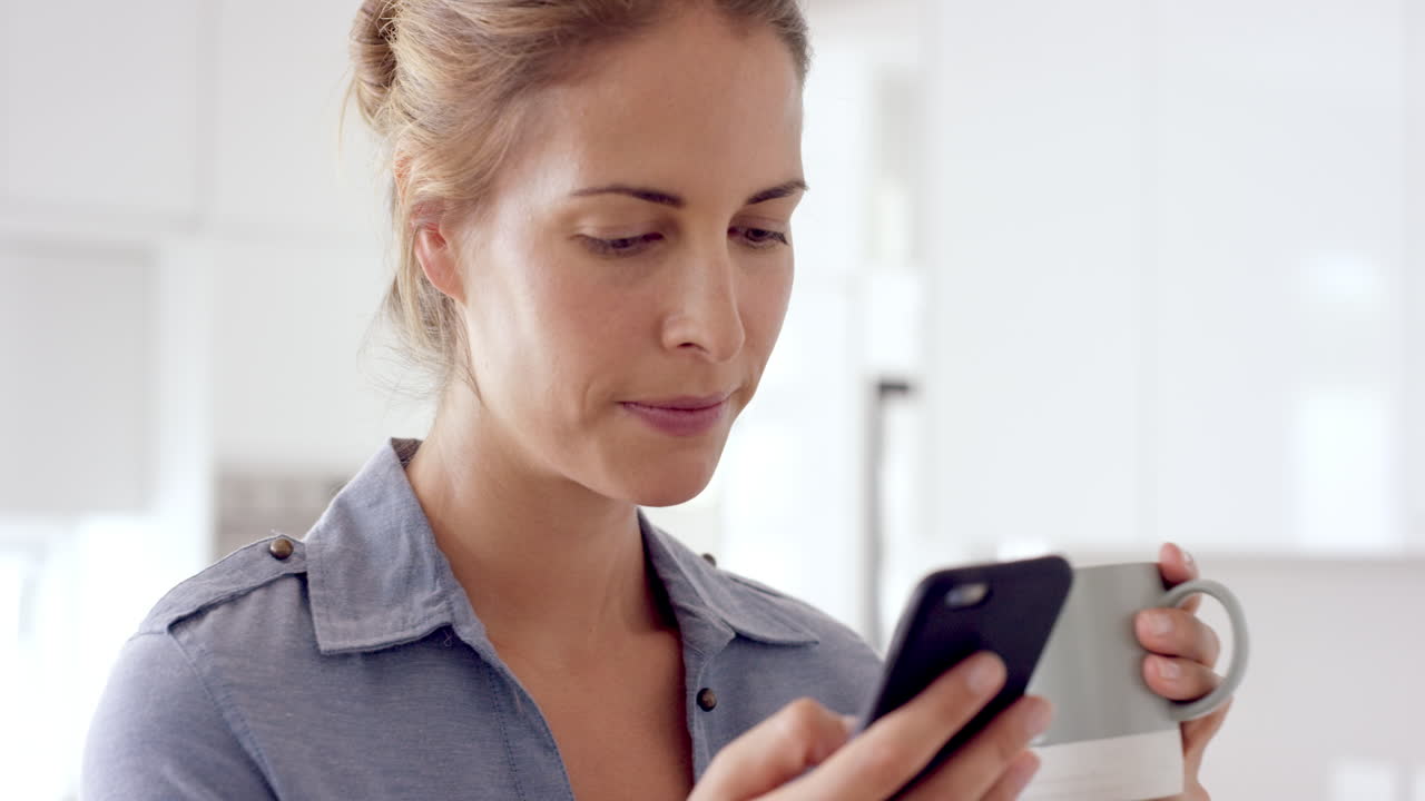 Eine Frau benutzt zu Hause ein Smartphone, trinkt Kaffee und genießt einen entspannten Lebensstil.