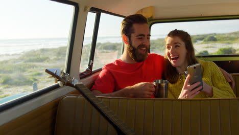 happy couple using mobile phone in the van 4k