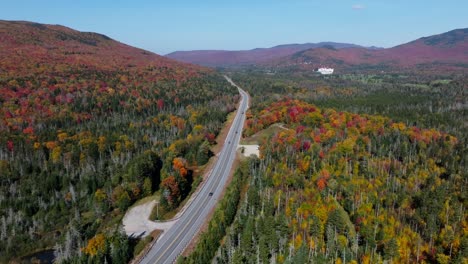 slow side pan of a road surrounded with the fall foliage in new hamsphire from an aerial perspective