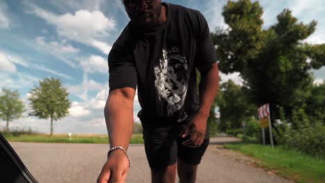 African-Man-Taking-Bag-Out-Of-Car-Trunk-In-Slow-Motion-at-Outdoor-Parking-Lot-In-Summer