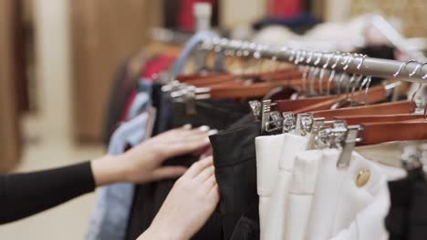 female-hands-closeup-looking-at-clothes-pants-and-sweaters