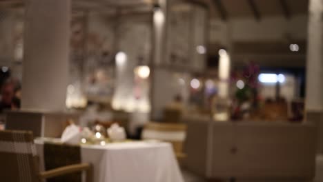 a dimly lit restaurant scene with blurred focus, capturing a serene and intimate dining atmosphere in thailand