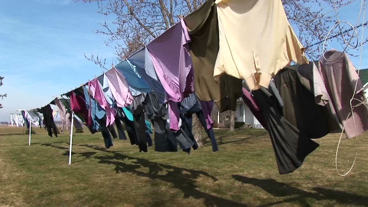 화려한 옷들이 야외 빨랫줄에 걸려 말리고 있다