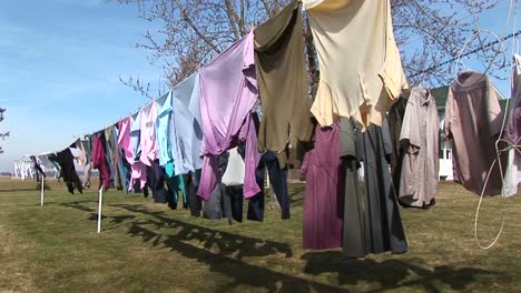 colorful clothes hang on an outdoor clothesline to dry