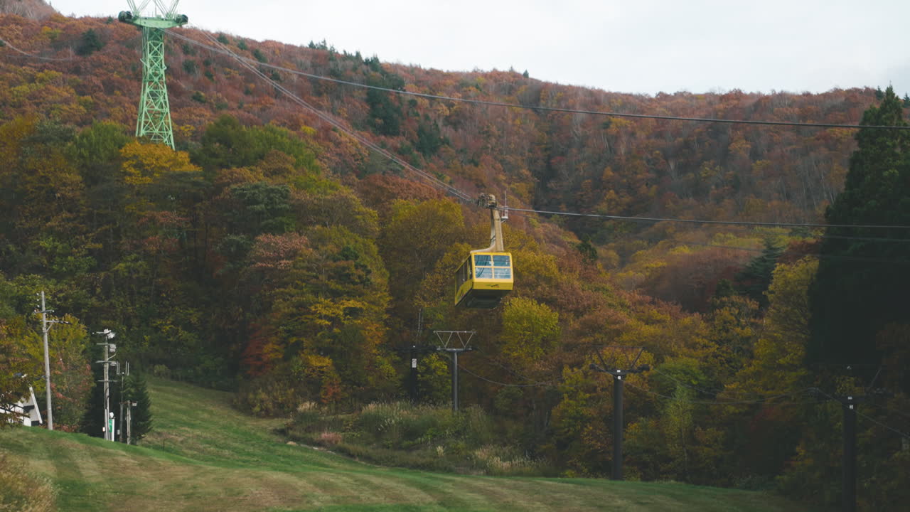 teleférico para turistas subiendo al monte zao con bosque otoñal al fondo