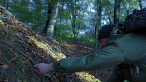 adult manclimbing up a steel mountain in forest during sunlight hike