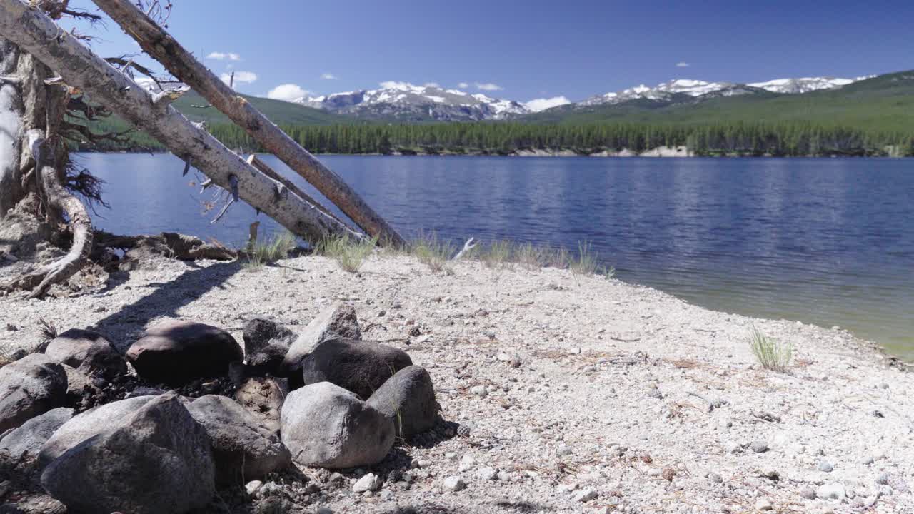 여름에 와이오밍에 있는 빅혼 국유림의 먼 배경에 구름 절정 황야가 있는 공원 저수지 기슭의 캠프장에서 불 링의 전망