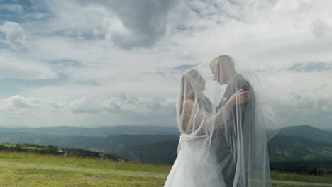 bride and groom kissing on a mountaintop