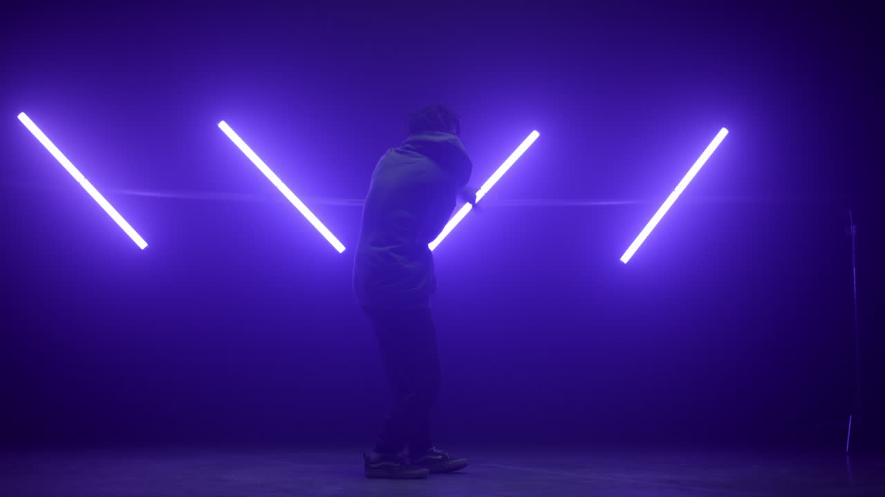 Ballerino che si esibisce in hip-hop in un night club. Silhouette di un b-boy che esegue movimenti agili.