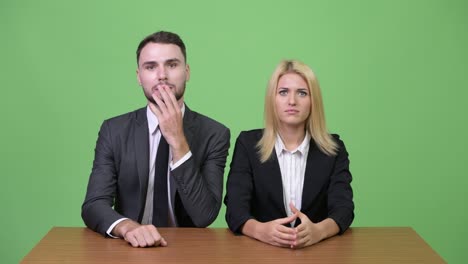 young businessman playing while working with young businesswoman focusing