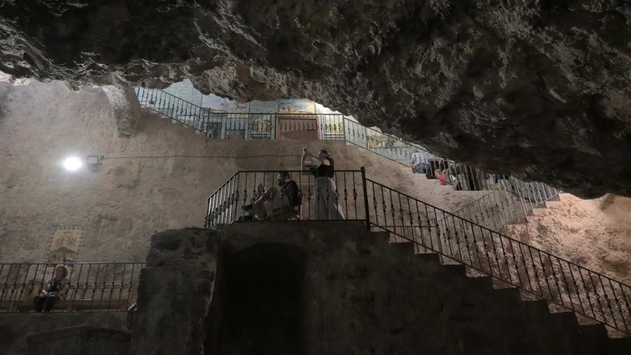 Tourists taking photographs on a staircase in the chapel of the Virgin of the Cave of the Sanctuary of the Holy Cave, in Altura, Castellón