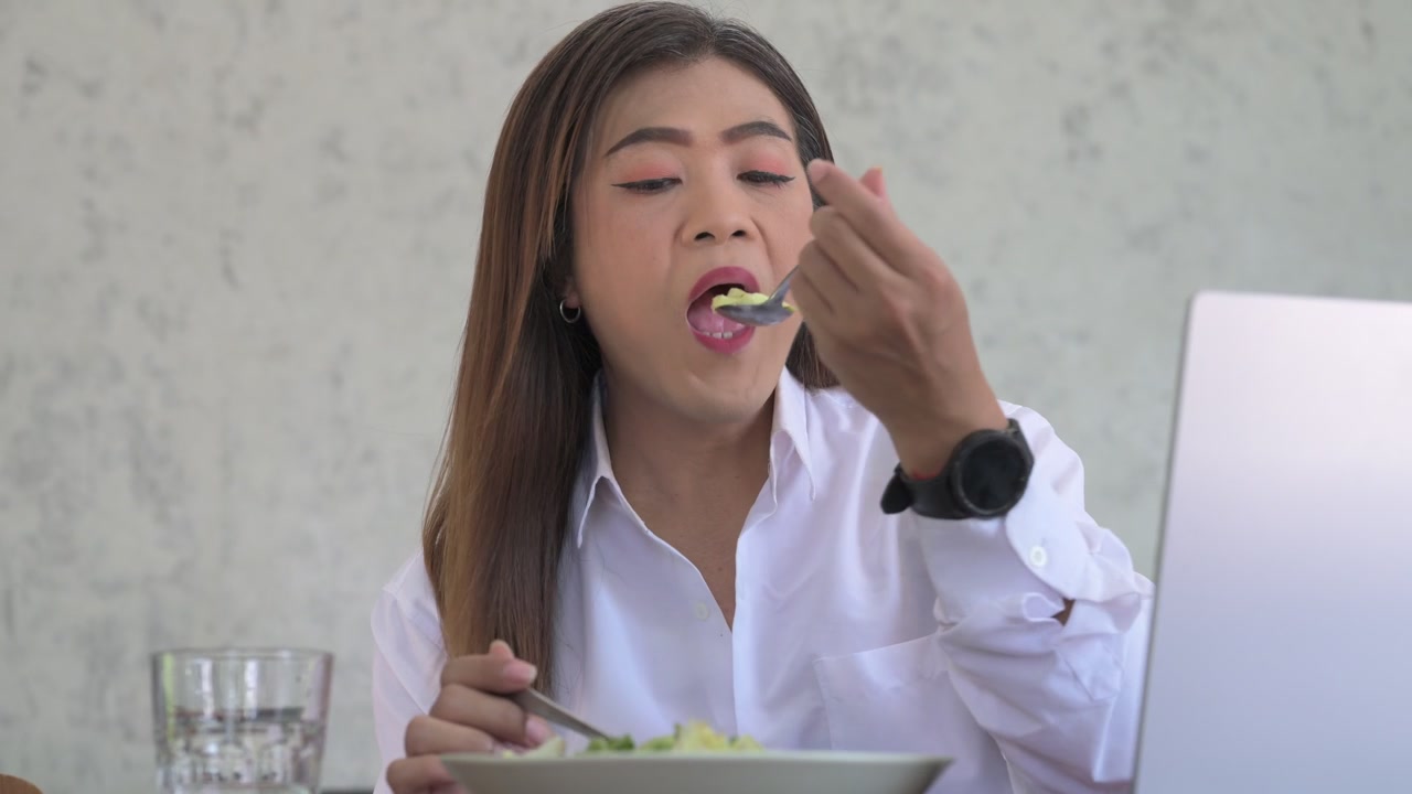 Portrait of a Thai Transgender Businesswoman Using Laptop and Eating Healthy Salad for Lunch