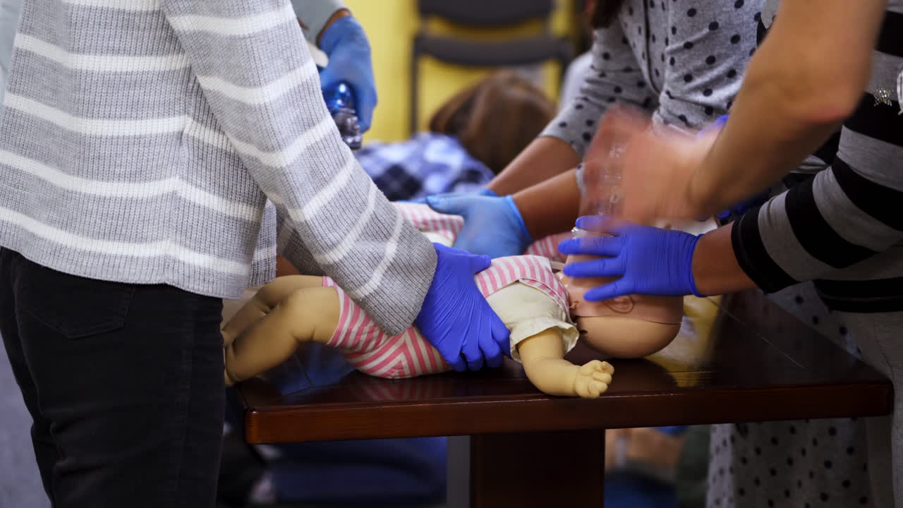 Training for first aid. Practitioners doing cardiopulmonary resuscitation on baby dummies. Training practice of a chest compression and breathing. Education of medicine.