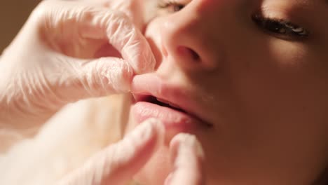 close-up of cosmetologist's hands examining lips