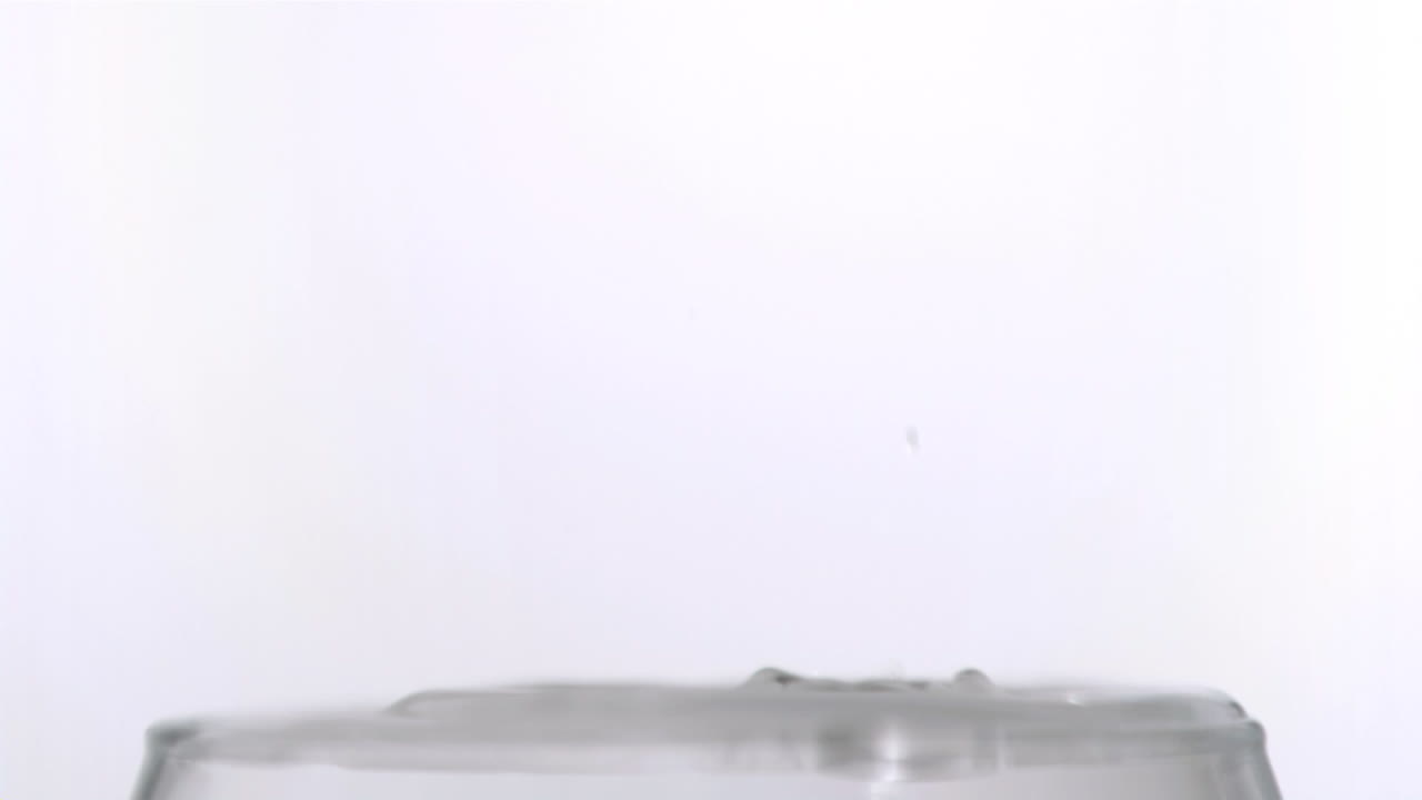 una gota cayendo en un vaso en súper cámara lenta