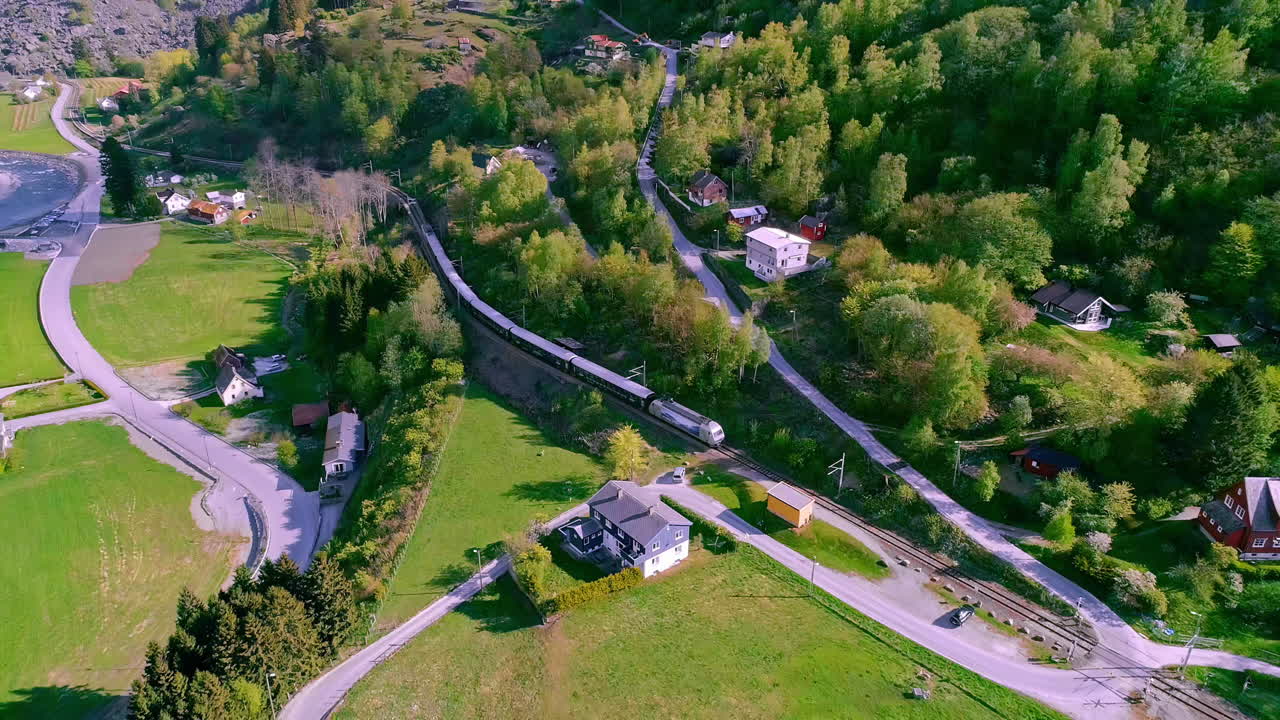 largo tren de pasajeros conduciendo en el valle vikingo en noruega en un día soleado